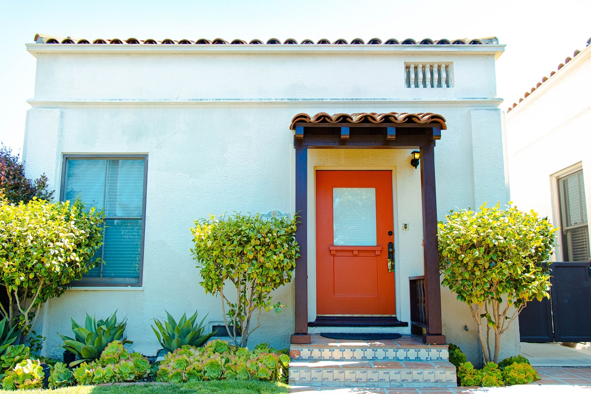 tiny home featuring a well-landscaped front yard and vibrant front door